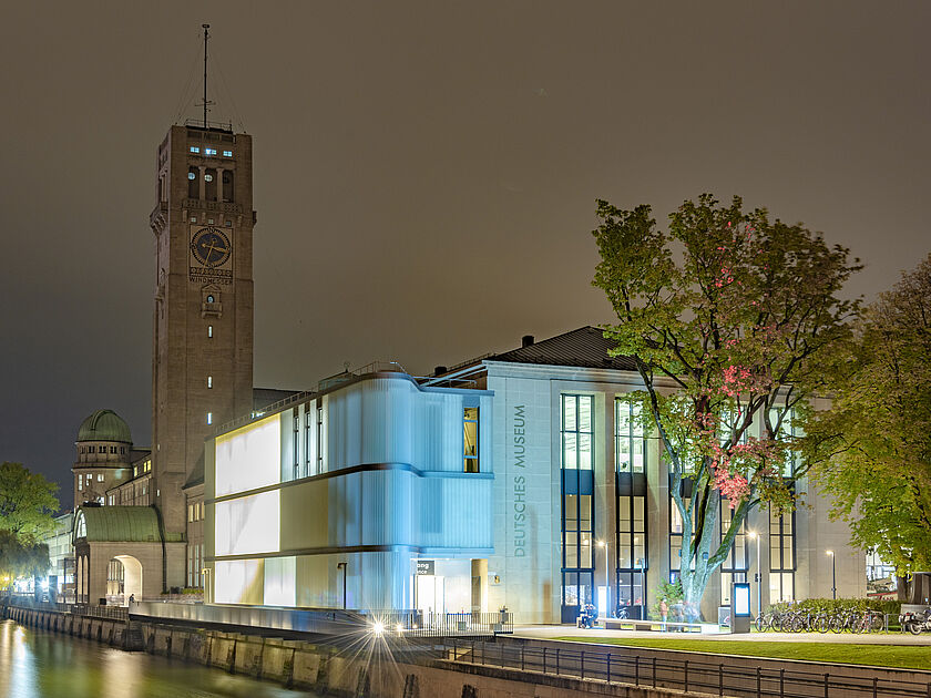 Nachtaufnahme des Deutschen Museums, mit Museumsturm und Eingangsbereich.