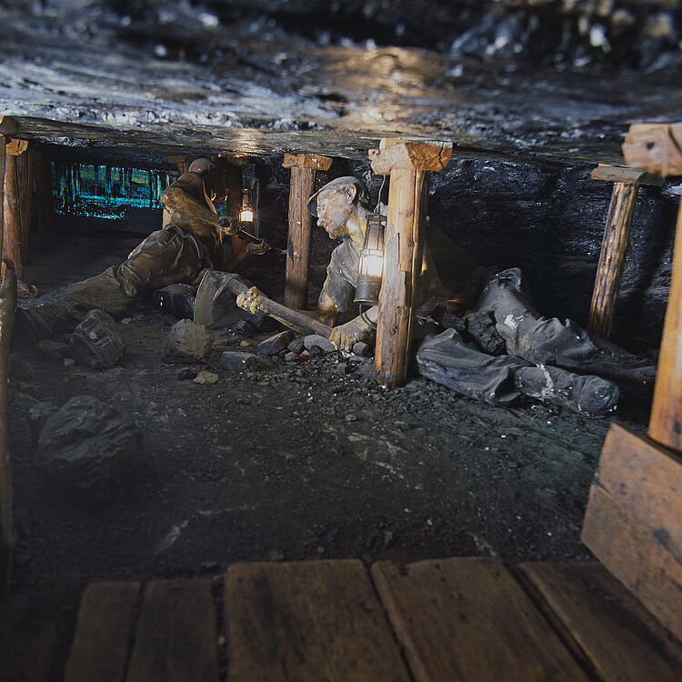 Ausstellung Bergwerk. Pechkohlenabbau in halbsteiler Lagerung. Mann unter Tage arbeitet.