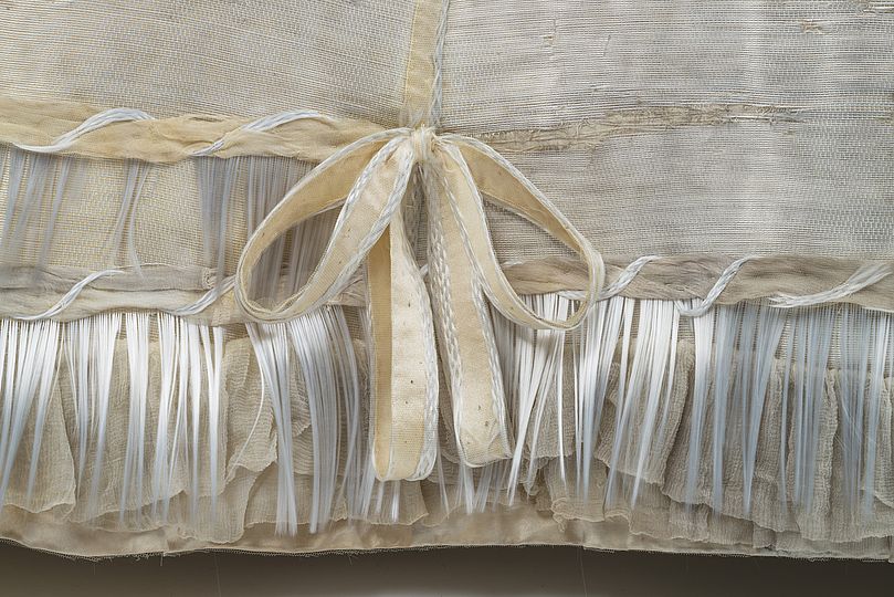 Detail of the ornately decorated hem of the skirt before conservation