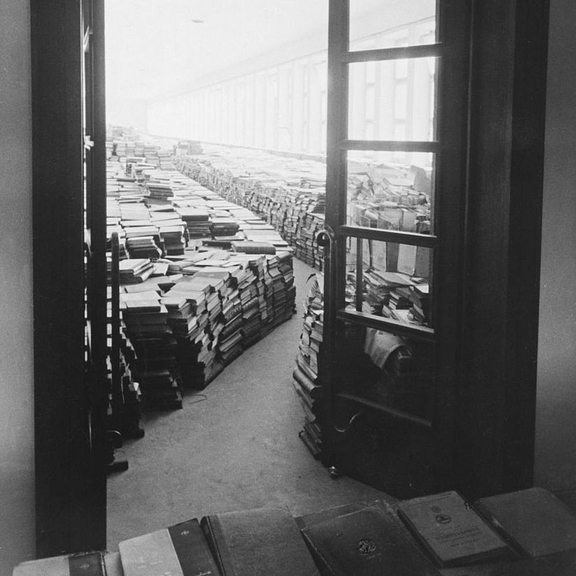 Der Lesesaal der Bibliothek beim Einzug des Deutschen Patentamts Bücherstapel stehen auf dem Boden des Lesesaals.