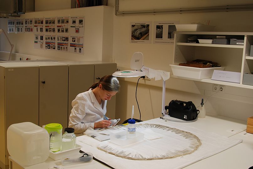 Reinigen der Fransenreihe vom Glasfaserkleid im Restaurierungsforschungslabor des Deutschen Museums