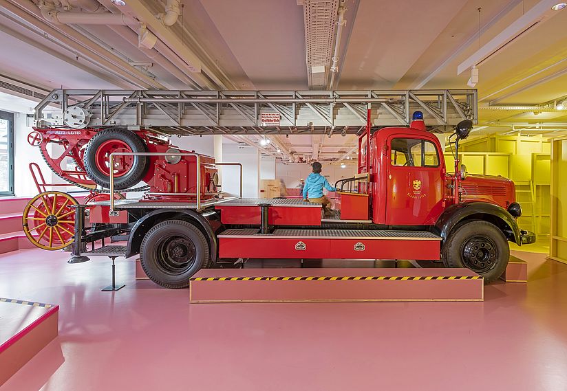 Junge sitzt auf dem großen Feuerwehrauto im Kinderreich.