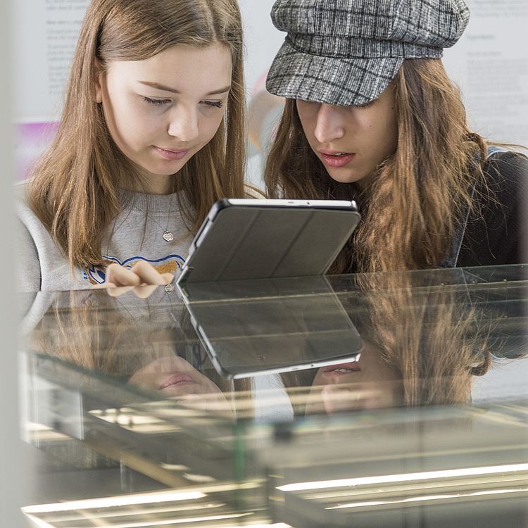 Mädchen mit Tablet in der Ausstellung.