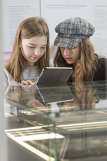 Mädchen mit Tablet in der Ausstellung.