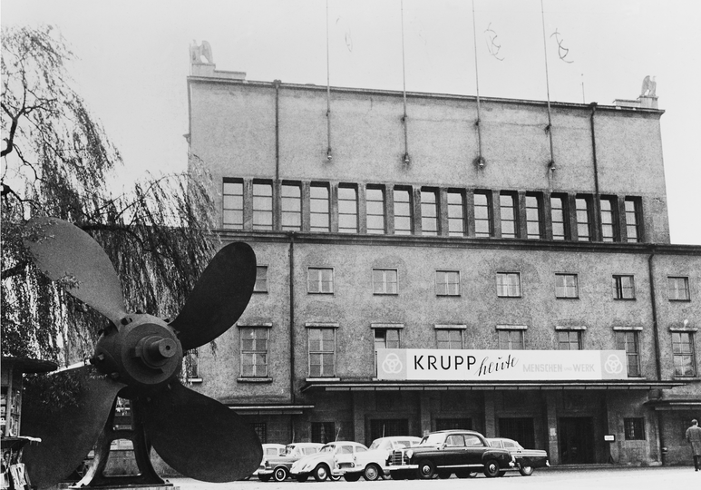 Schwarzweiß Fotografie vom Forum der Zukunft mit einem Banner von Krupp