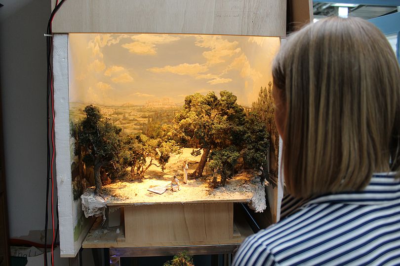 Frau betrachtet ein Diorama (Schaukasten).