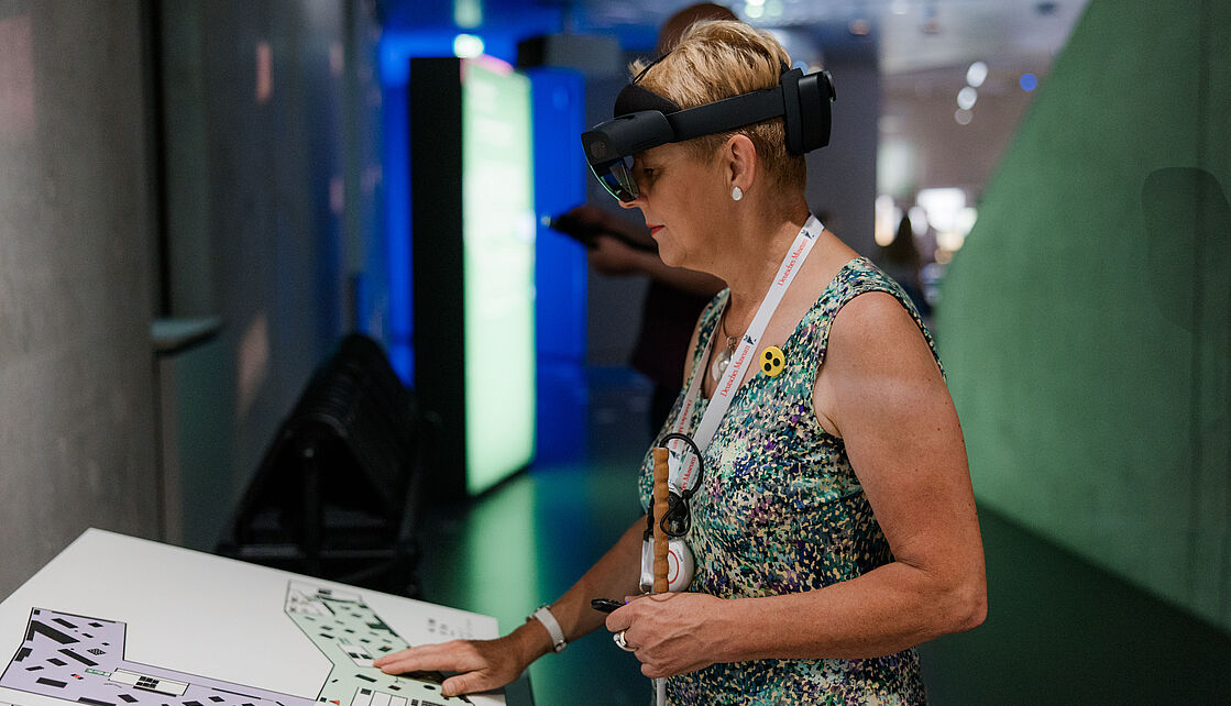 Blinde Frau im Zukunftsmuseum Eine blinde Frau an einem taktilen Übersichtsplan im Zukunftsmuseum.