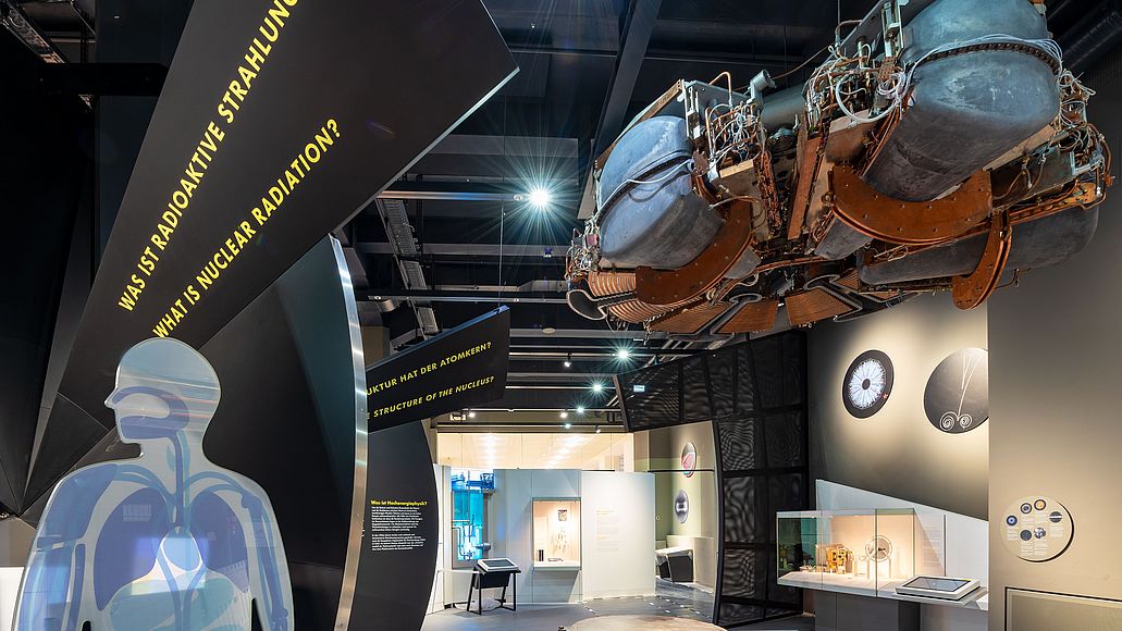 Einblick in die Ausstellung Atomphysik. Ausschnitt eines Menschen mit Organen zum Thema radioaktive Strahlung.