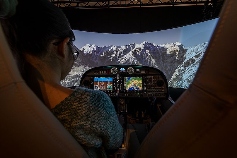 Frau steuert Flugsimulator 