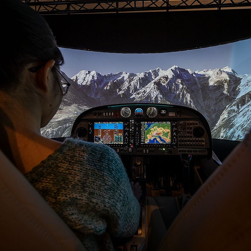 Frau steuert Flugsimulator