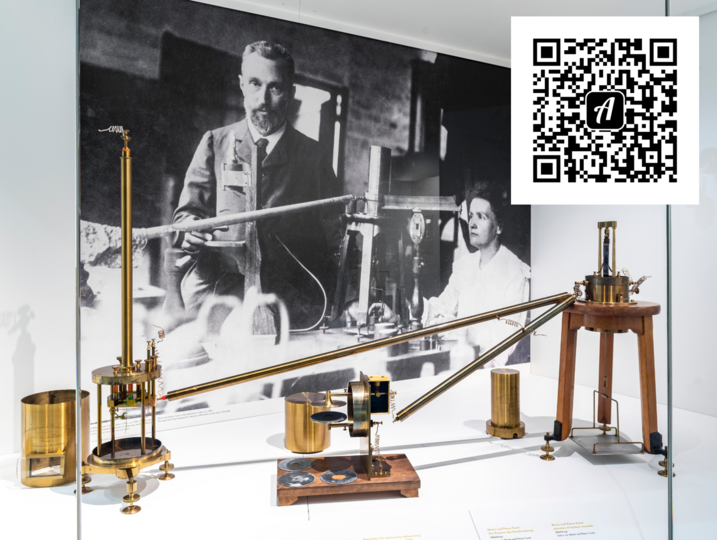 Apparatur von Marie und Pierre Currie in der Ausstellung Atomphysik. De QR-Code zum Bound "Erkundet die Atomphysik mit Actionbound" befindet sich rechts oben in der Ecke.