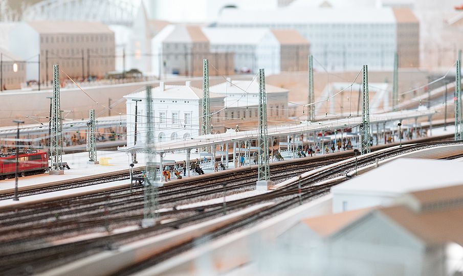 Detail der Modellbahn. Bahnhof und wartende Passagiere auf dem Bahnsteig.