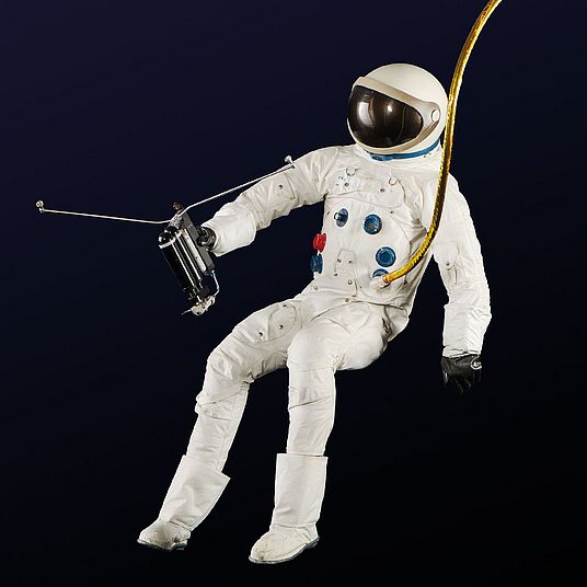 Astronaut mit Weltraumanzug schwebt im luftleeren Raum.