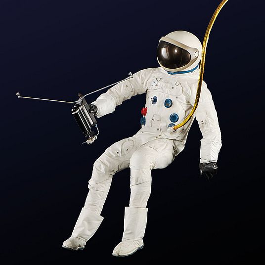 Astronaut mit Weltraumanzug schwebt im luftleeren Raum.