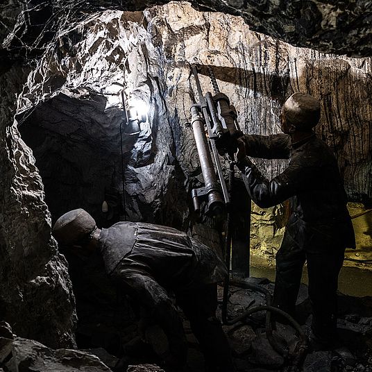 Bergarbeiter bedienen einen Bohrer