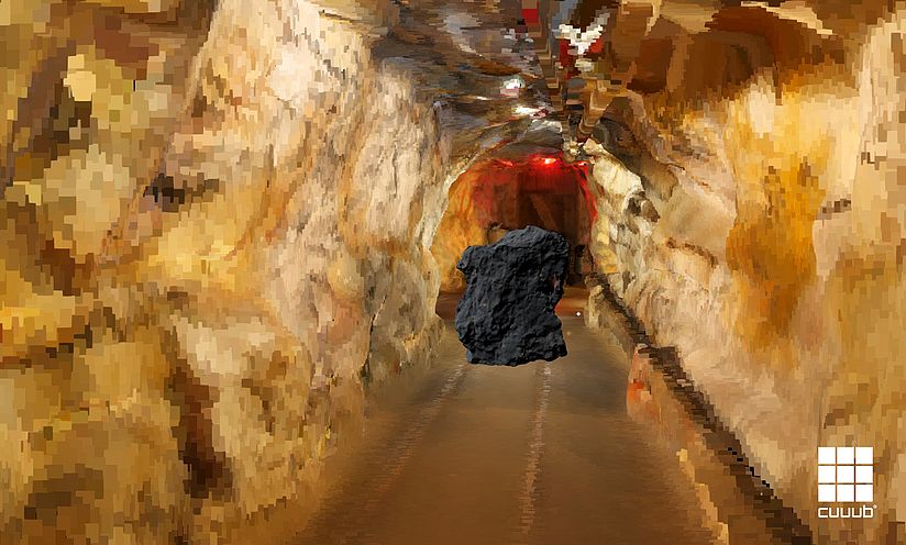 Ein Erzklumpen fliegt in einer animierten Bergwerksumgebung durch einen Stollen.