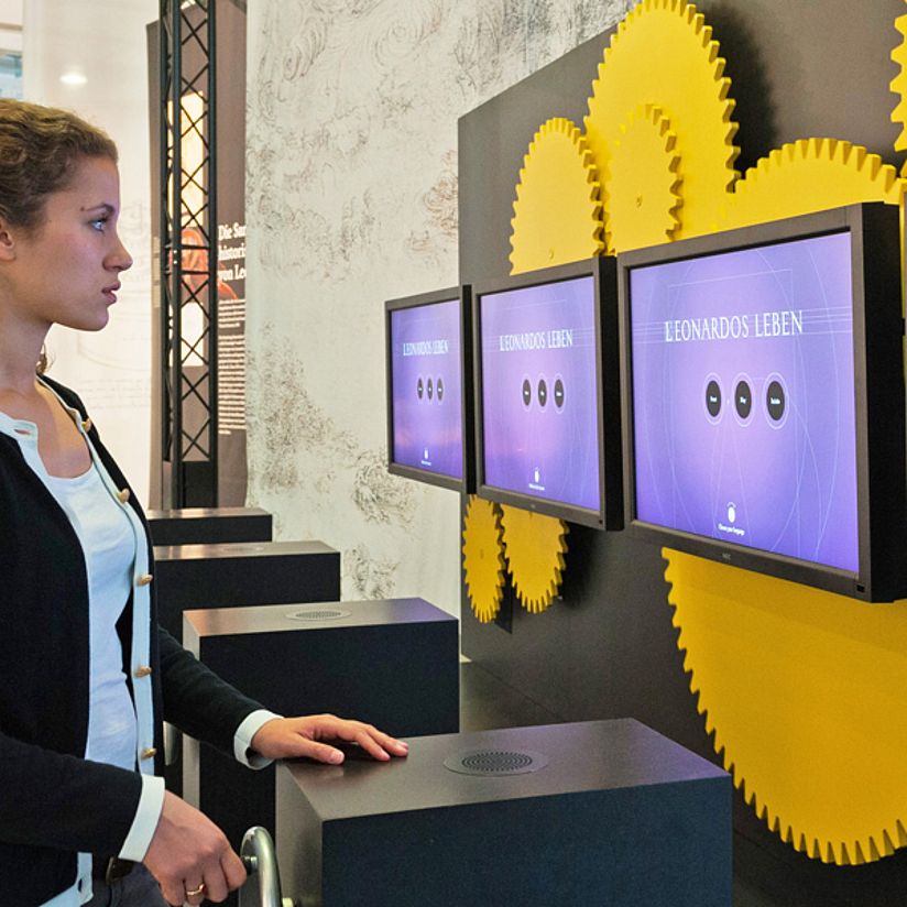 Frau an der Medienstation über Leonardo da Vincis Leben.