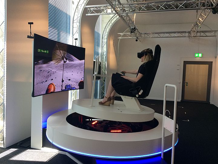 Woman with a VR headset in the driving simulator.
