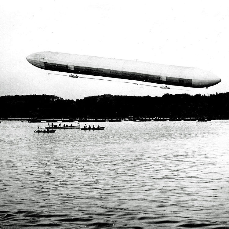 Schwarz-weiß Foto zeigt das erste Zeppelin-Luftschiff über der Manzeller Bucht.