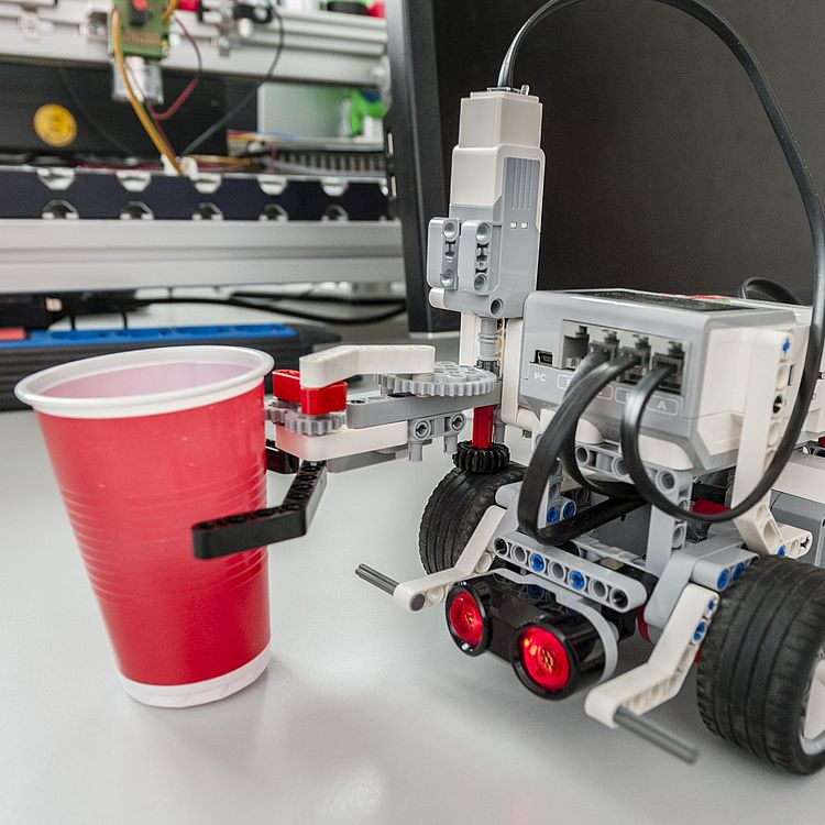 EV3-Roboter hält ein Plastikbecher.
