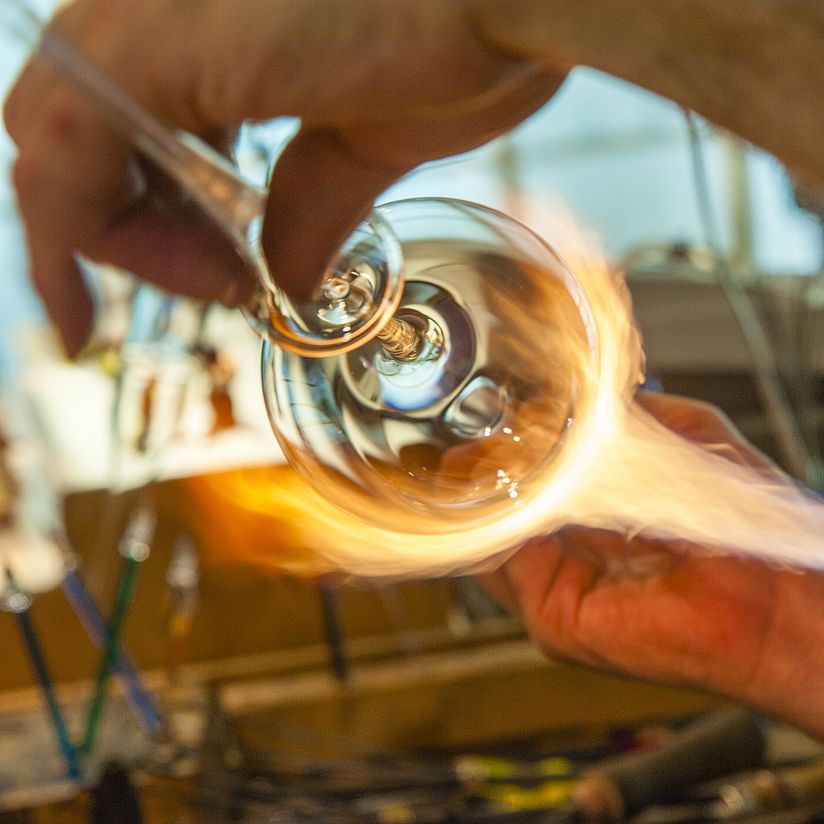 Glasbläser erhitzt das Glas.