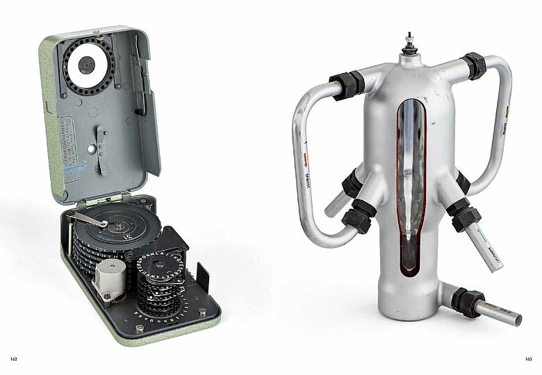 Links eine aufgeklappte Box mit Zahnrädern, rechts eine komnische Metallform