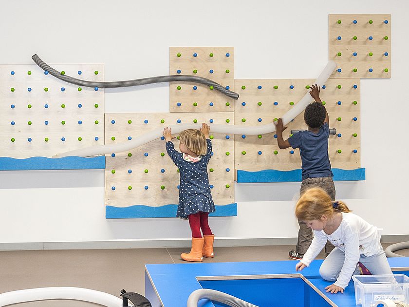 Kinder spielen im Kinderreich mit der Kugelbahn.