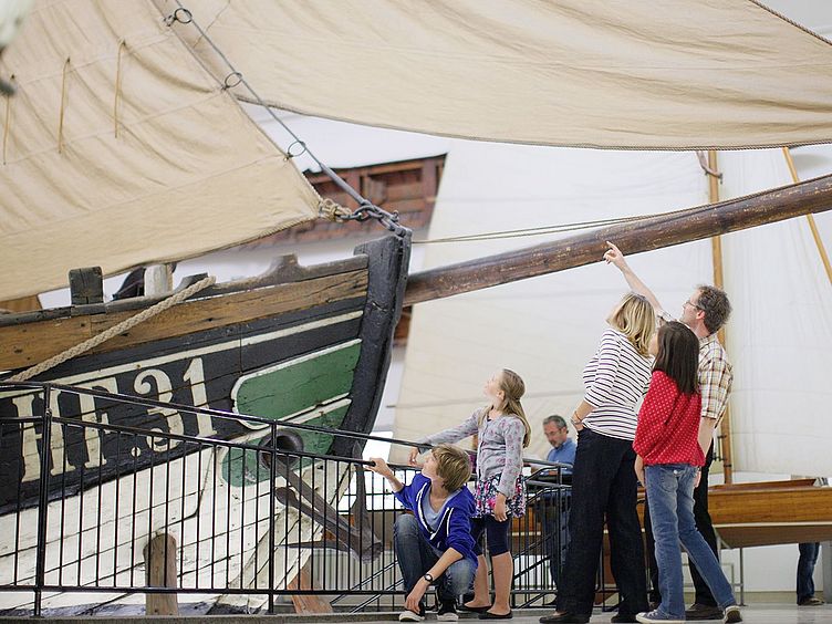Ausstellung_Schifffahrt_Fischer Ewer_DtMuseum_1801.jpg Familie vor Fischer-Ewer „Maria“