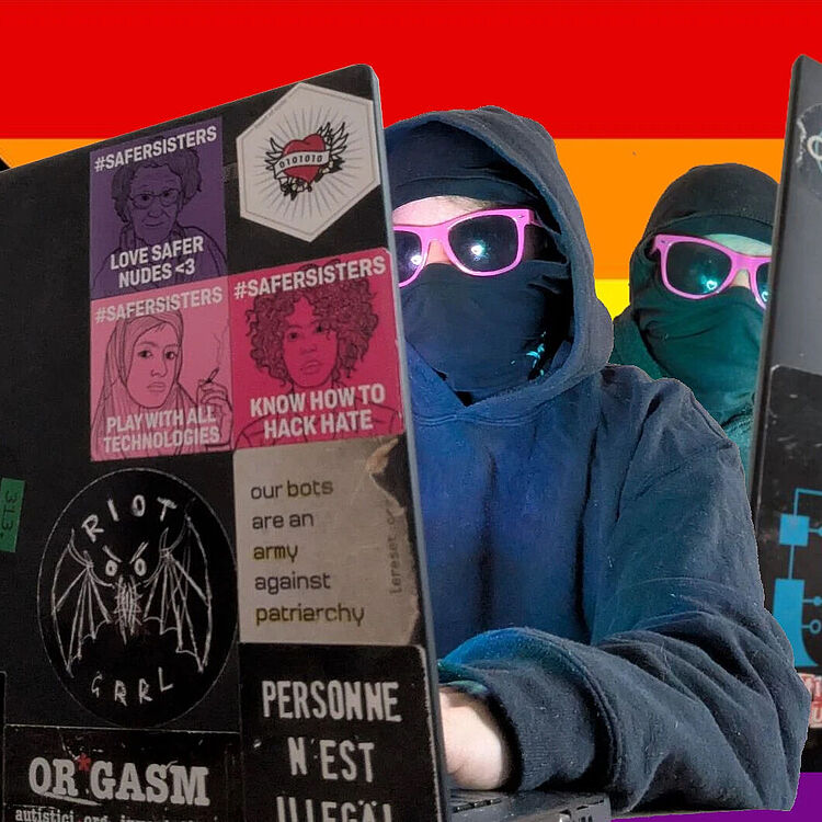 Zwei maskierte Personen in Kapuzenpullovern und pinken Sonnenbrillen sitzen an Laptops, die mit feministischen und politischen Stickern beklebt sind. Im Hintergrund ist eine bunte Pride-Flaggen-Collage zu sehen.