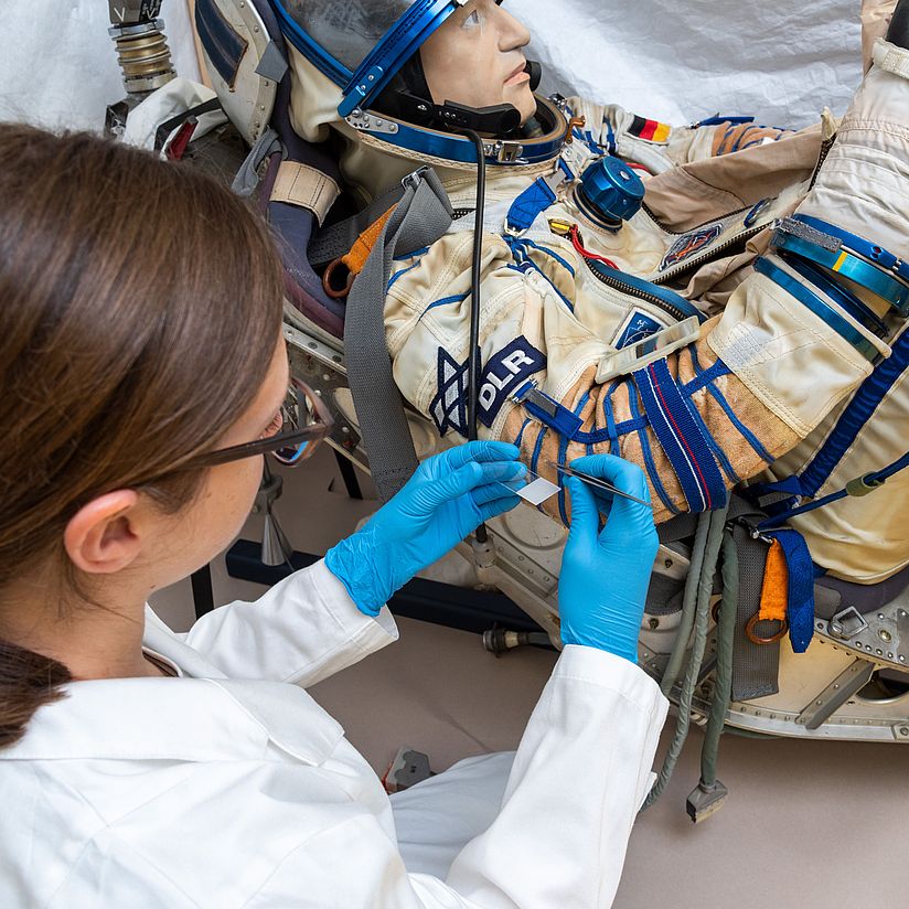 Conservator Charlotte Holzer taking material samples from the Sokol-KV-2 spacesuit