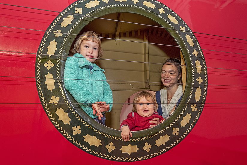 Mutter mit ihren zwei Kindern in der Riesengitarre im Kinderreich.