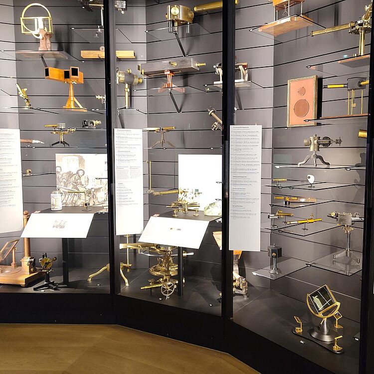 Das Foto zeigt eine Großvitrine die mit einer Vielzahl vonoptischen Instrumenten gefüllt ist.