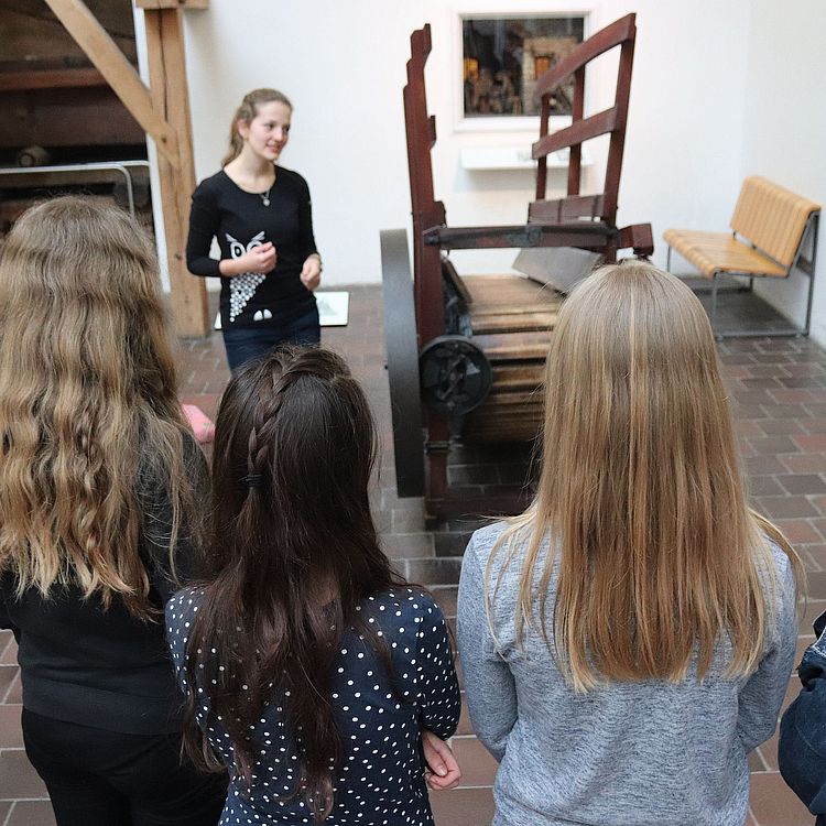 Robotik-Workshop: Schülerinnen sehen bei einer Präsentation in der Ausstellung zu.