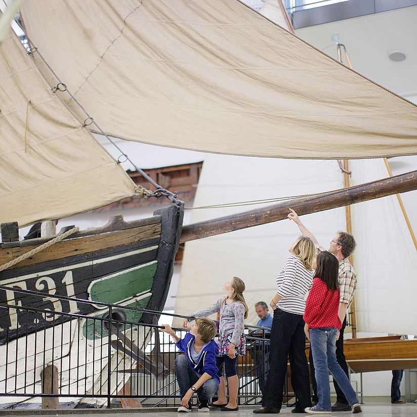 Deutsches_Museum_Besuch_Familien_Fischer_Ewer Familie steht vor dem Fischerboot Ewer.