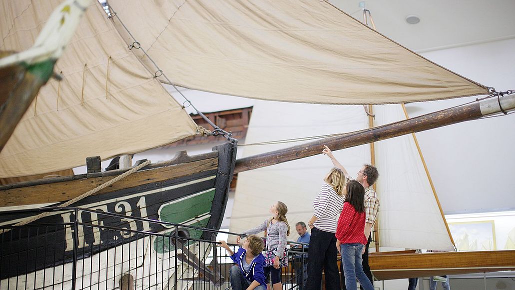 Deutsches_Museum_Besuch_Familien_Fischer_Ewer Familie steht vor dem Fischerboot Ewer.
