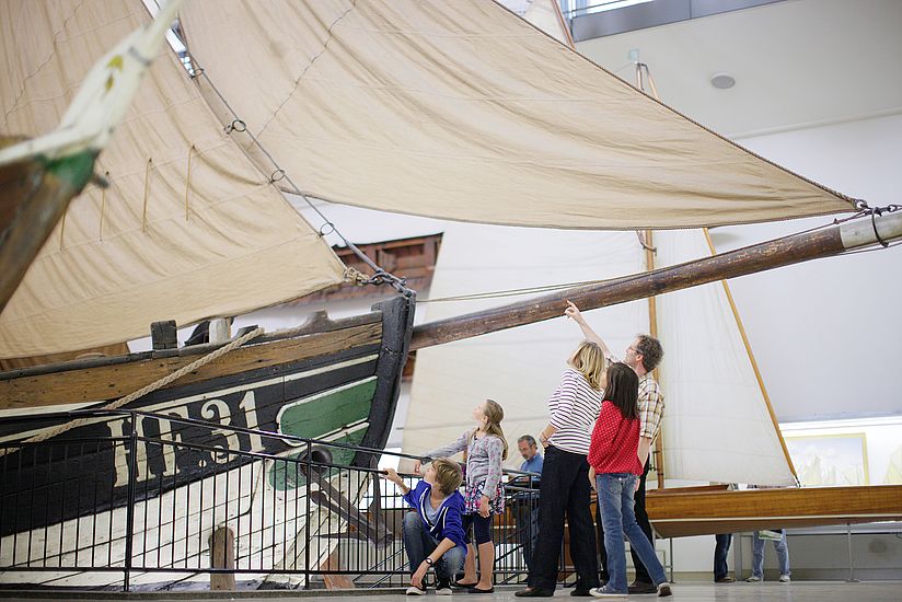 Deutsches_Museum_Besuch_Familien_Fischer_Ewer Familie steht vor dem Fischerboot Ewer.