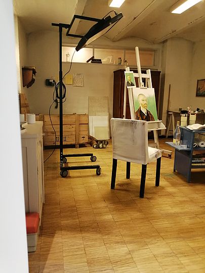 Diorama zeigt einen Ausschnitt des Malerateliers des Deutschen Museums. Zu sehen sind ein weißer Stuhl, eine Deckenhohe Stehlampe und ein Replik Van Goghs Selbstbildnisses auf einer Staffelei.
