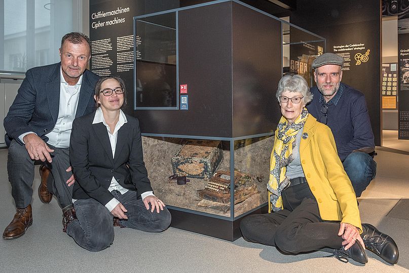 Enkel Andreas Langer, Kryptologie-Kuratorin Carola Dahlke, Menzers Tochter Gudrun Jackson und Filmemacher Robert Jahn vor der Vitrine mit dem Schlüsselgerät 41 in der Ausstellung Bild Schrift Codes.