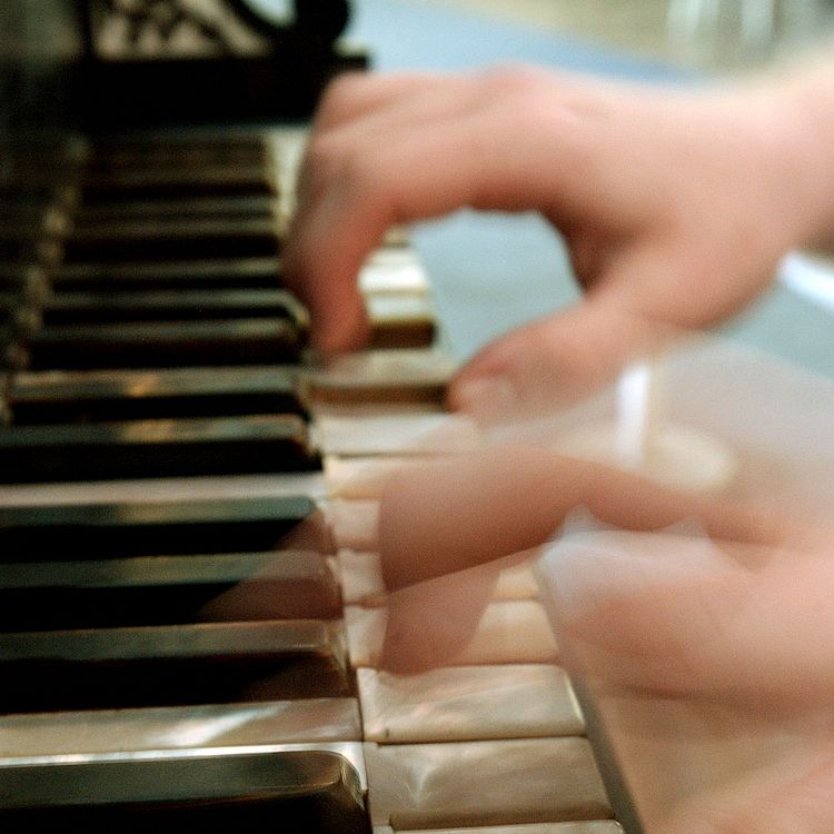 Hände spielen auf einem Keyboard.