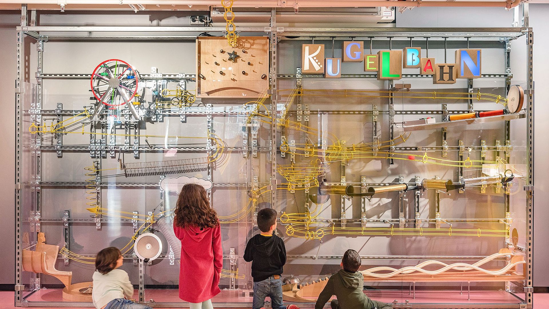 Kinder beaobachten die Kugelbahn im Kinderreich.