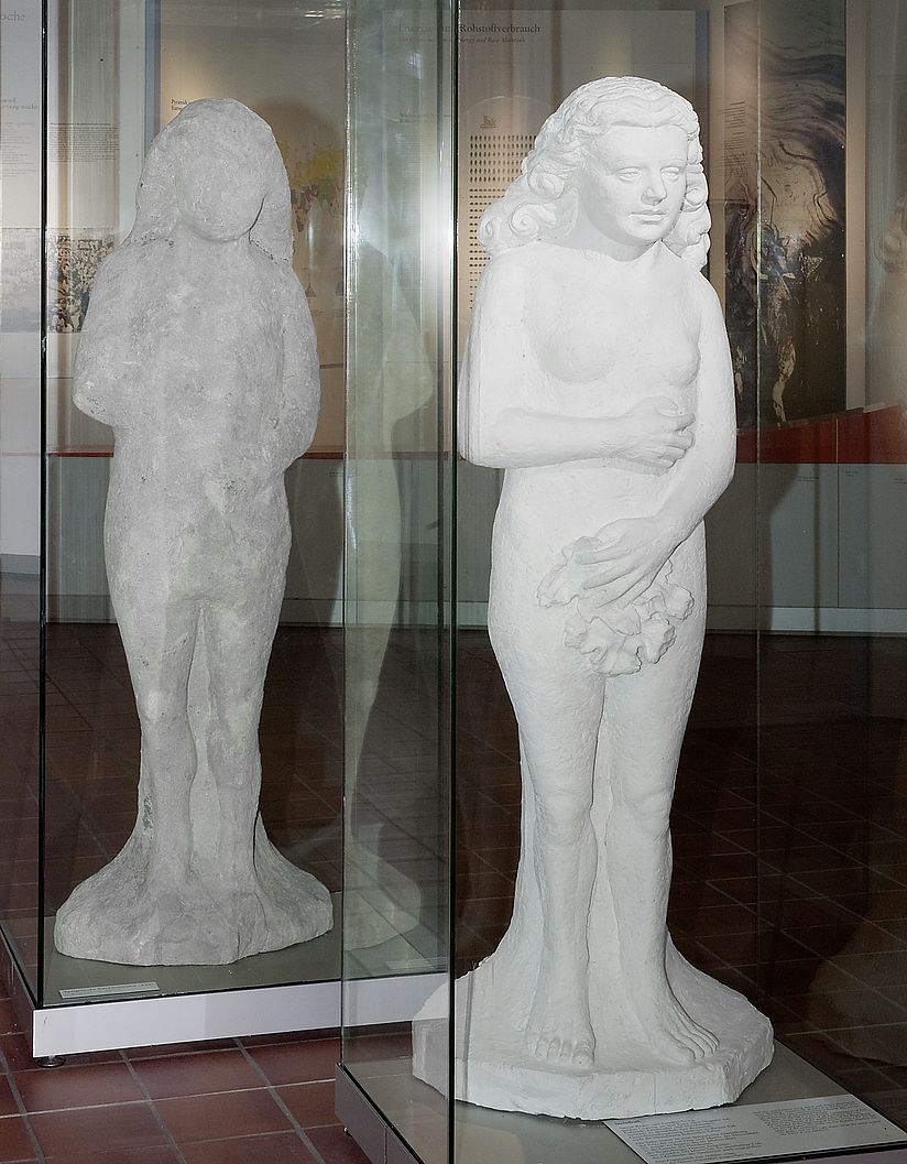 Statues of Eve, sandstone statue from the 16th century and plaster model from the 20th century. The sandstone statue is a late Gothic representation of Eve and has been corroded by acid rain. The plaster model next to it shows how the statue looked originally, before it was corroded.