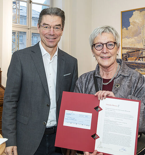 ein Mann und eine Frau mit einer roten Urkunde