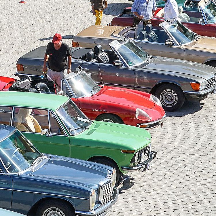 Besucher besichtigen Oldtimer auf dem Vorplatz des Verkehrszentrums