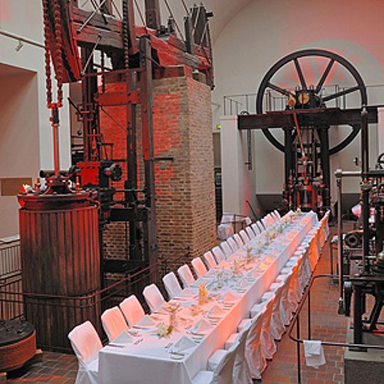 Abendveranstaltung in der Ausstellung Kraftmaschinen mit einer langen, gedeckten Tafel.