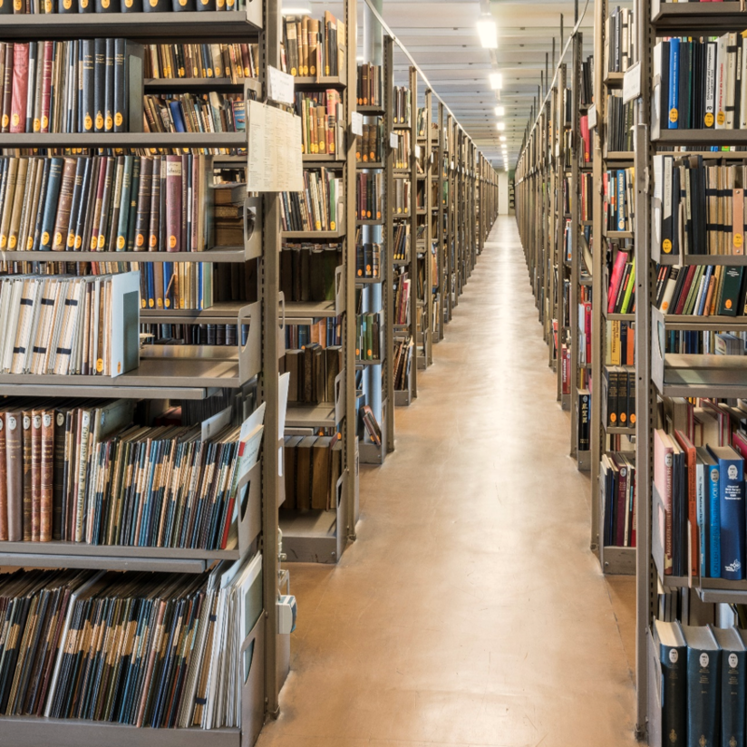 Zwischen den Bücherregalen im Magazin. Ein langer Gang zwischen den Bücherregalen im Bibliotheksmagazin