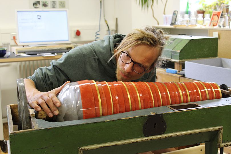 Restaurator untersucht eine Glasharmonika in der Restaurierungswerkstatt.