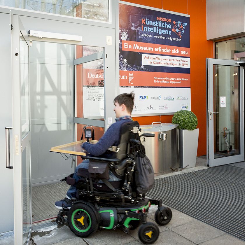 Außenlift vor Haupteingang Deutsches Museum Bonn mit Rollstuhlfahrer.