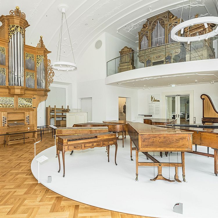 Blick in den ersten Raum der Ausstellung Musikinstrumente mit zwei großen Orgeln und weiteren Tasteninstrumenten.