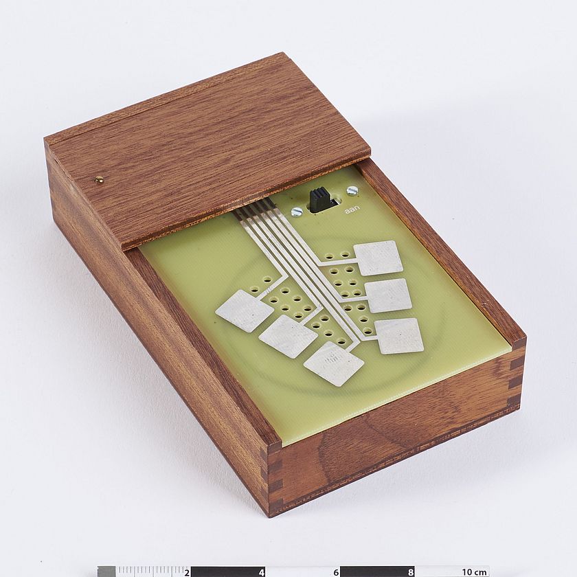 Die Cracklebox zur Erzeugung elektronsicher Live-Musik leicht schräg positioniert mit Holzverkleidung und 6 weißen Kontaktflächen zur Steuerung