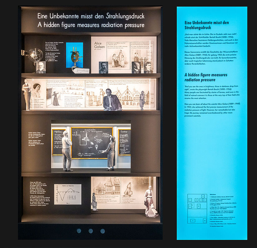 Eine Vitrine mit Zeichnungen und Collagen, ausgeschnittenen Figuren und nachgebauten Modellen. 